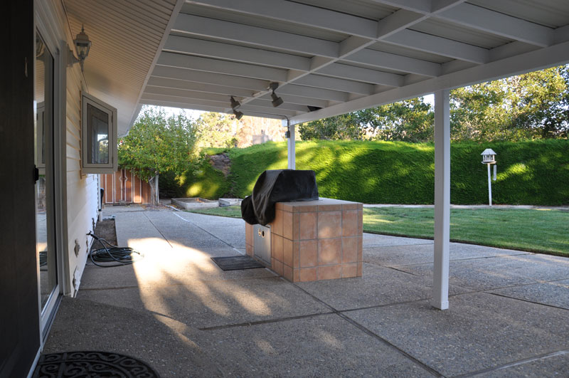 Backyard has covered patio and built-in gas grill